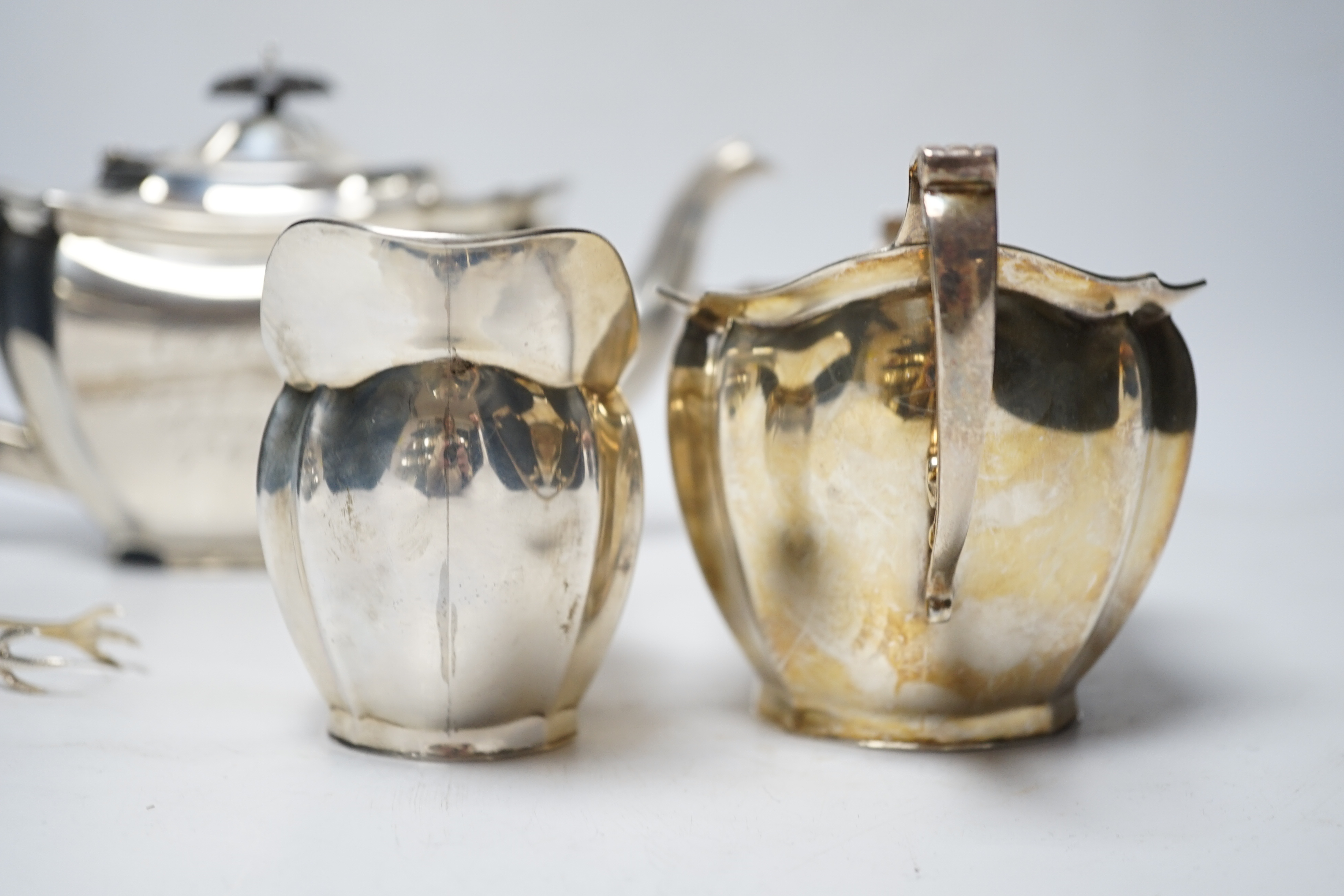 A George V three piece silver tea set by Robert Pringle & Sons, London, 1933, with engraved inscription, together with a pair of associated silver sugar tongs, gross weight 40.7oz.